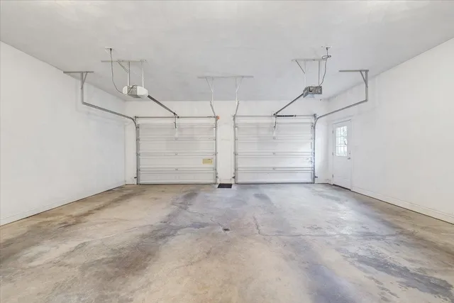 an empty room with wooden floor fireplace and windows