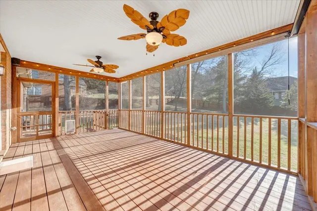 a view of an empty room with wooden floor and windows