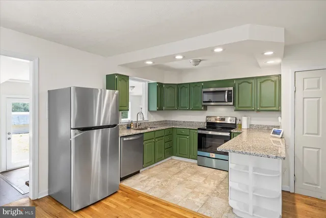 a kitchen with stainless steel appliances granite countertop a refrigerator stove microwave and sink