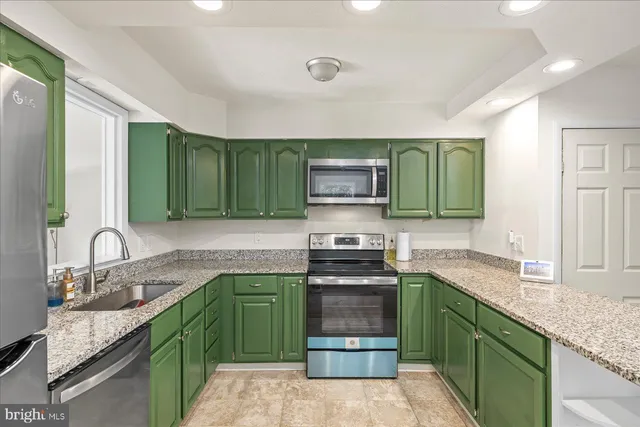 a kitchen with kitchen island granite countertop a sink and stove top oven