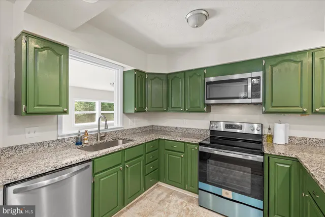 a kitchen with stainless steel appliances granite countertop a sink stove and microwave