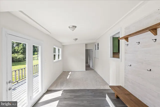 a view of a hallway with wooden floor and windows