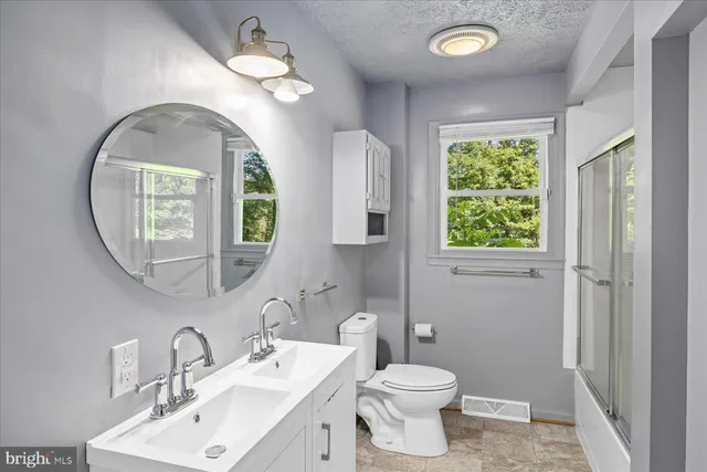 a bathroom with a toilet a sink and a mirror