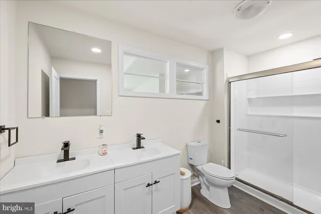 a bathroom with a toilet a sink a mirror and vanity