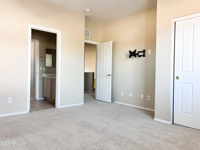 an empty room with closet and a bathroom