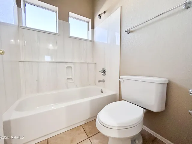 a bathroom with a white toilet and bathtub