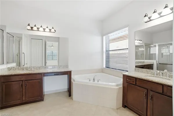 a bathroom with a tub sink and mirror