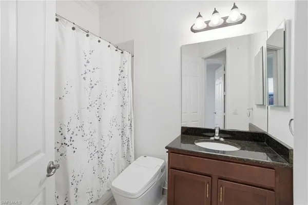 a bathroom with a granite countertop sink toilet and shower