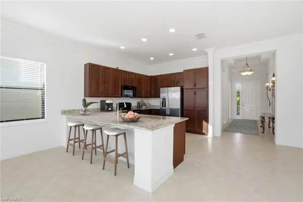 a kitchen with stainless steel appliances kitchen island granite countertop a refrigerator and a stove top oven