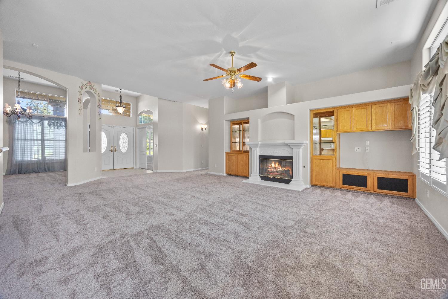 Undisclosed Address Bakersfield, CA 93312 - Photo 13 of 45 a view of a livingroom with a fireplace a chandelier and windows