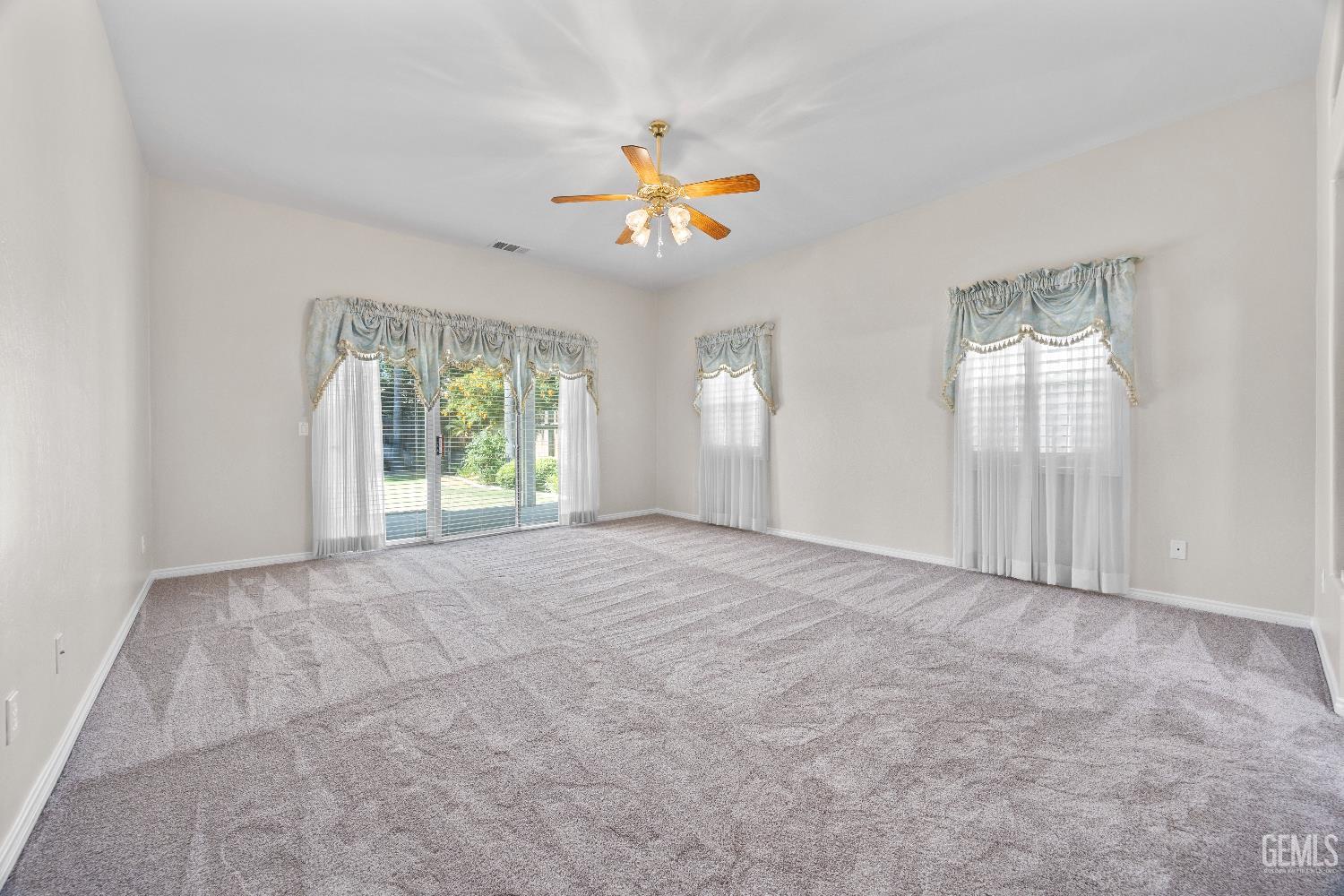 Undisclosed Address Bakersfield, CA 93312 - Photo 24 of 45 an empty room with windows and chandelier fan