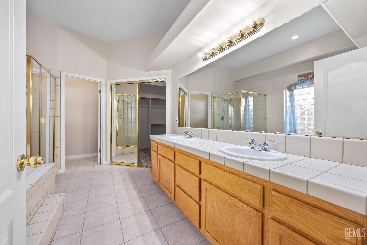 Undisclosed Address Bakersfield, CA 93312 - Photo 26 of 45 a spacious bathroom with a granite countertop sink a mirror and a bathtub