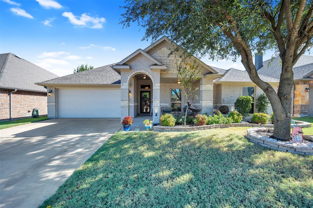 a front view of a house with a yard and potted plants