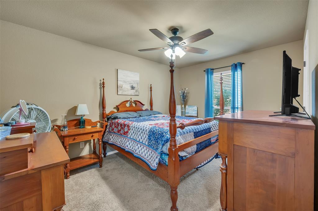 1663 Potomac Drive Burleson, TX 76028 - Photo 13 of 25 a bedroom with a bed and a flat tv screen on the dresser