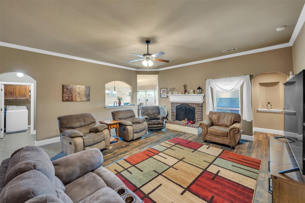 1663 Potomac Drive Burleson, TX 76028 - Photo 5 of 25 a living room with furniture a fireplace and a chandelier