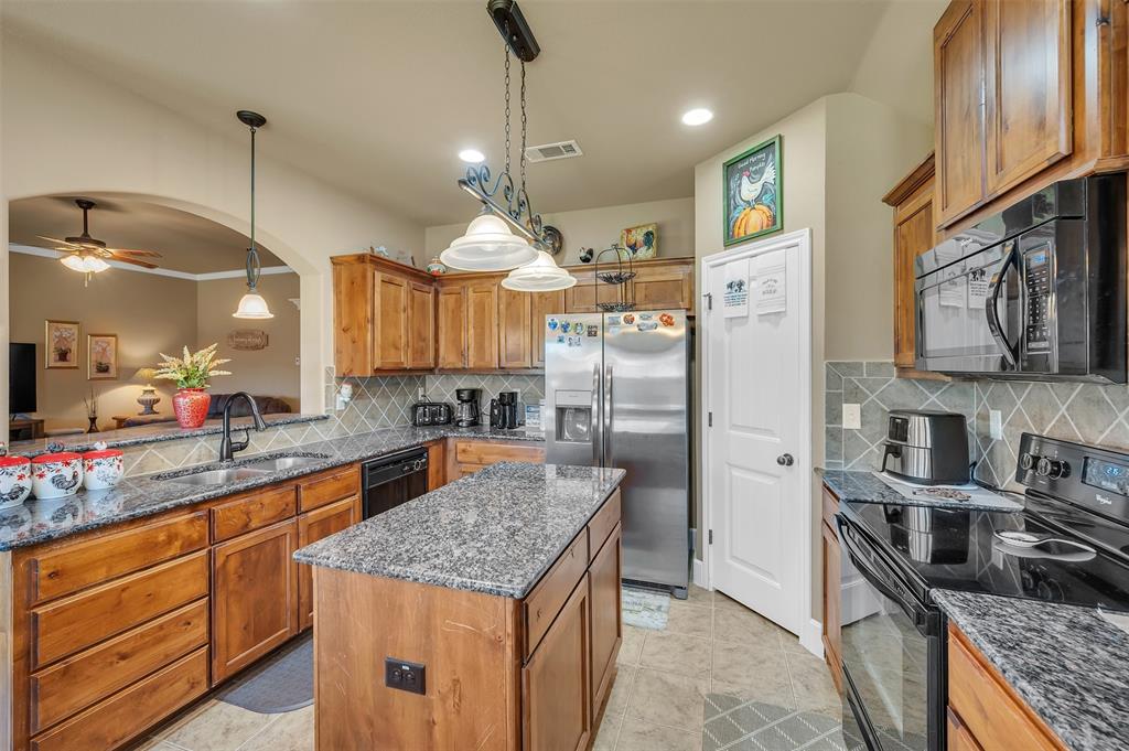 1663 Potomac Drive Burleson, TX 76028 - Photo 7 of 25 a kitchen with granite countertop a sink a counter space appliances and cabinets