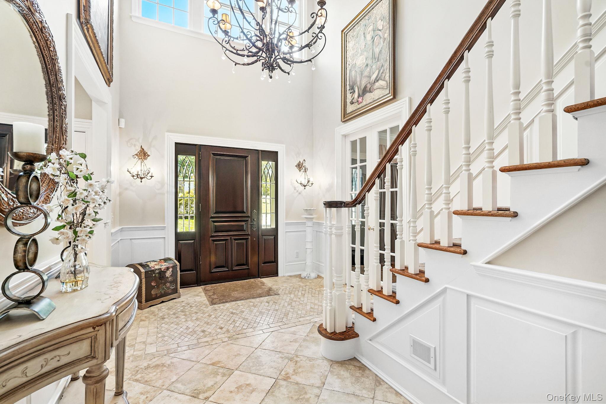 33 Hevelyne Road Elmsford, NY 10523 - Photo 4 of 43 Foyer entrance with a wainscoted wall, a decorative wall, a high ceiling, light tile patterned floors, and stairs