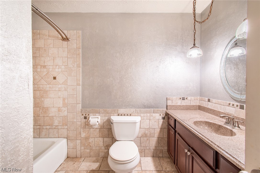 6038 Tippecanoe Road Canfield, OH 44406 - Photo 15 of 34 Full bathroom with toilet, tile walls, vanity with extensive cabinet space, tile flooring, and tiled shower / bath