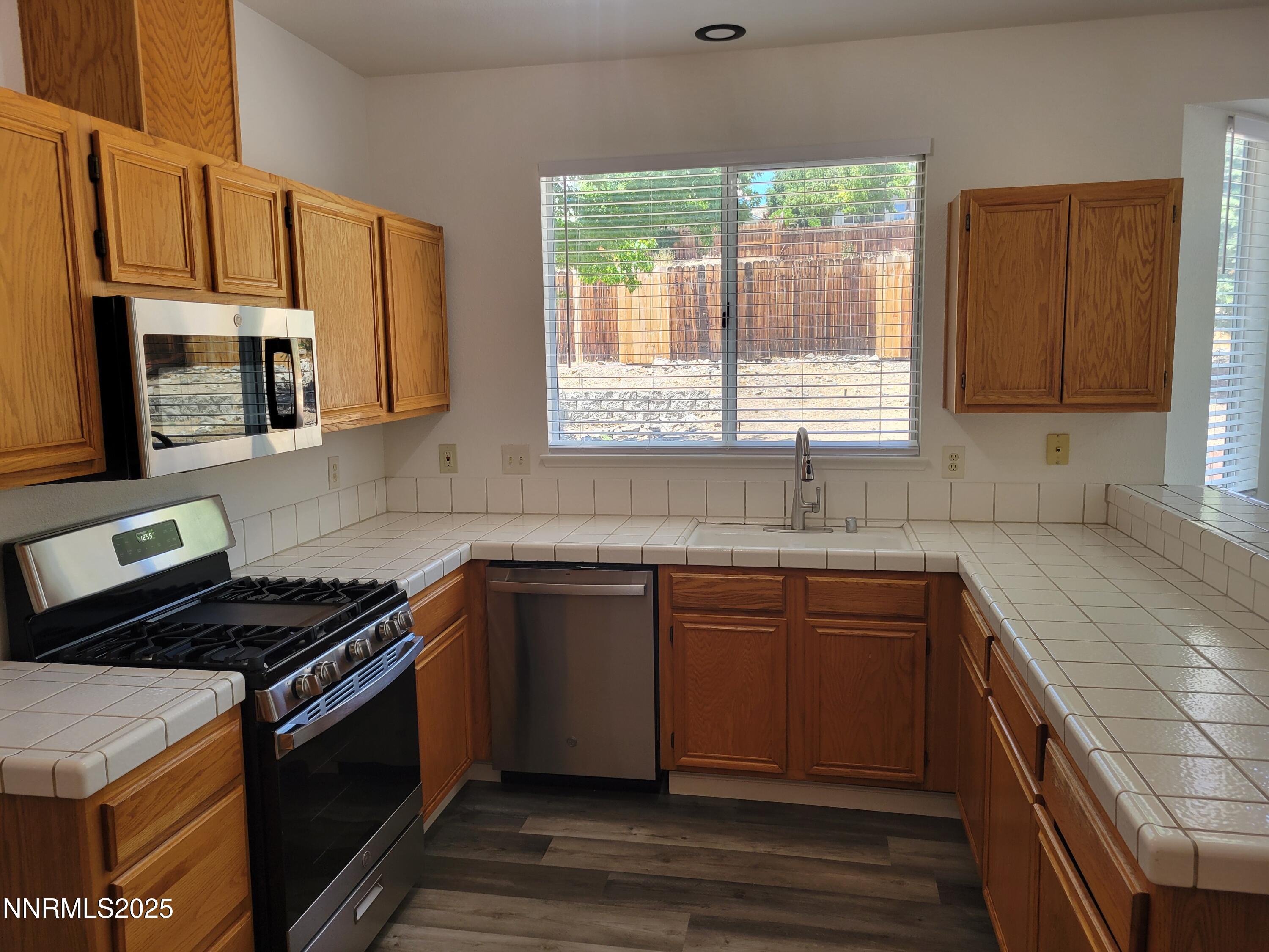 2967 Aspendale Drive Reno, NV 89503 - Photo 4 of 20 a kitchen with stainless steel appliances a stove sink microwave and window