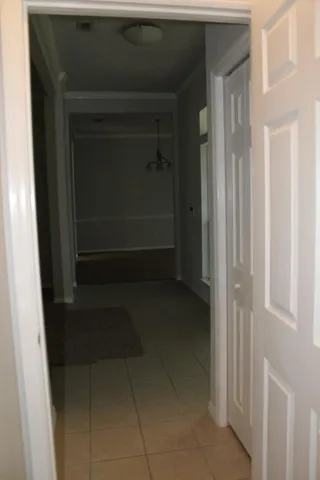 a view of an empty room with chandelier and fireplace