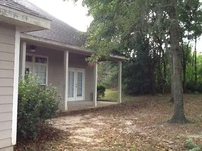 a view of a house with a yard and large tree