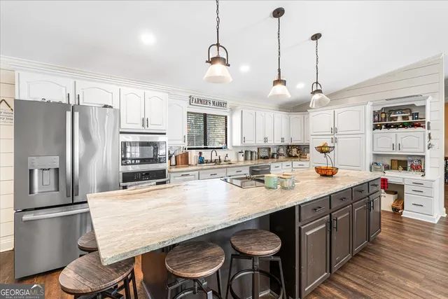 a kitchen with stainless steel appliances granite countertop a sink a stove and refrigerator