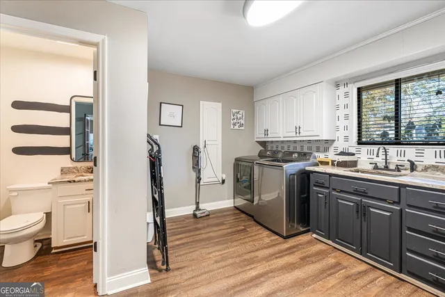a kitchen with a sink stove and wooden floor