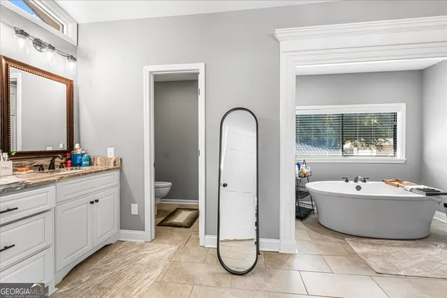 a bathroom with a tub sink and mirror