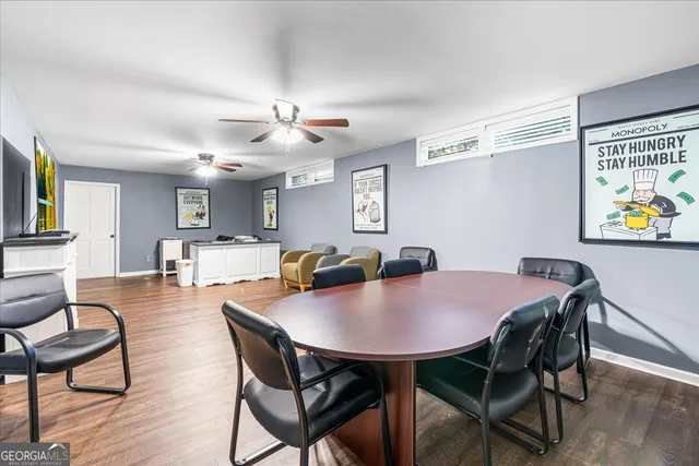 a view of an empty room with wooden floor and a ceiling fan