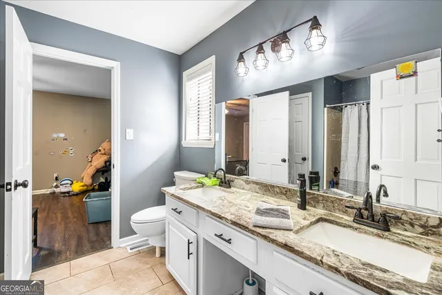 a en suite bathroom with a double vanity sink and mirror