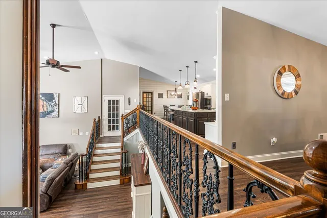 a view of a hallway with wooden floor and staircase