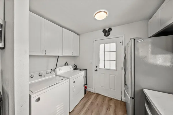 a utility room with cabinets washer and dryer
