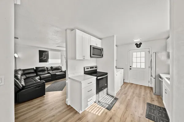 a kitchen with granite countertop a stove top oven a sink dishwasher and a refrigerator