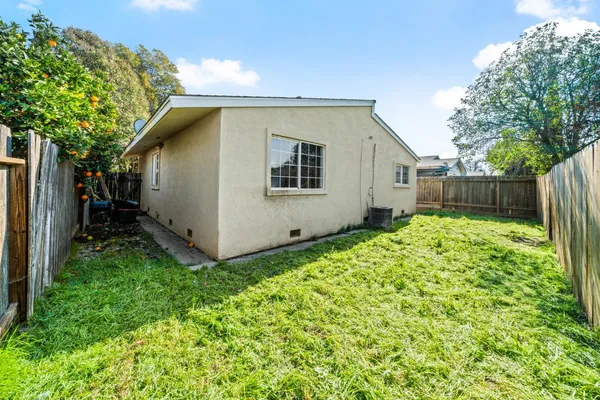 a view of backyard with potted plants and wooden fence