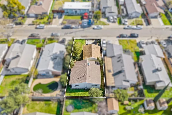 an aerial view of residential houses with outdoor space and parking