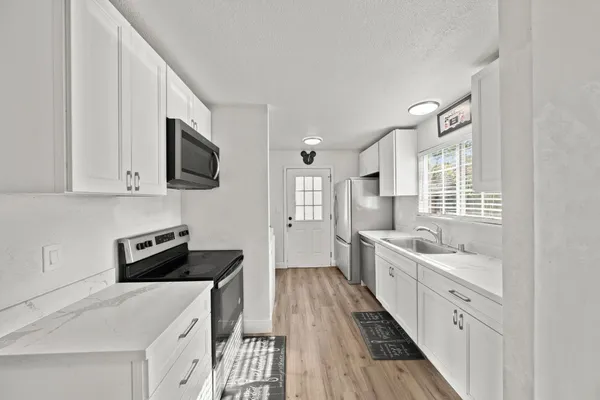 a kitchen with a sink stove and microwave