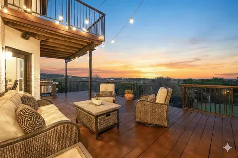 a view of couch on wooden deck with city view