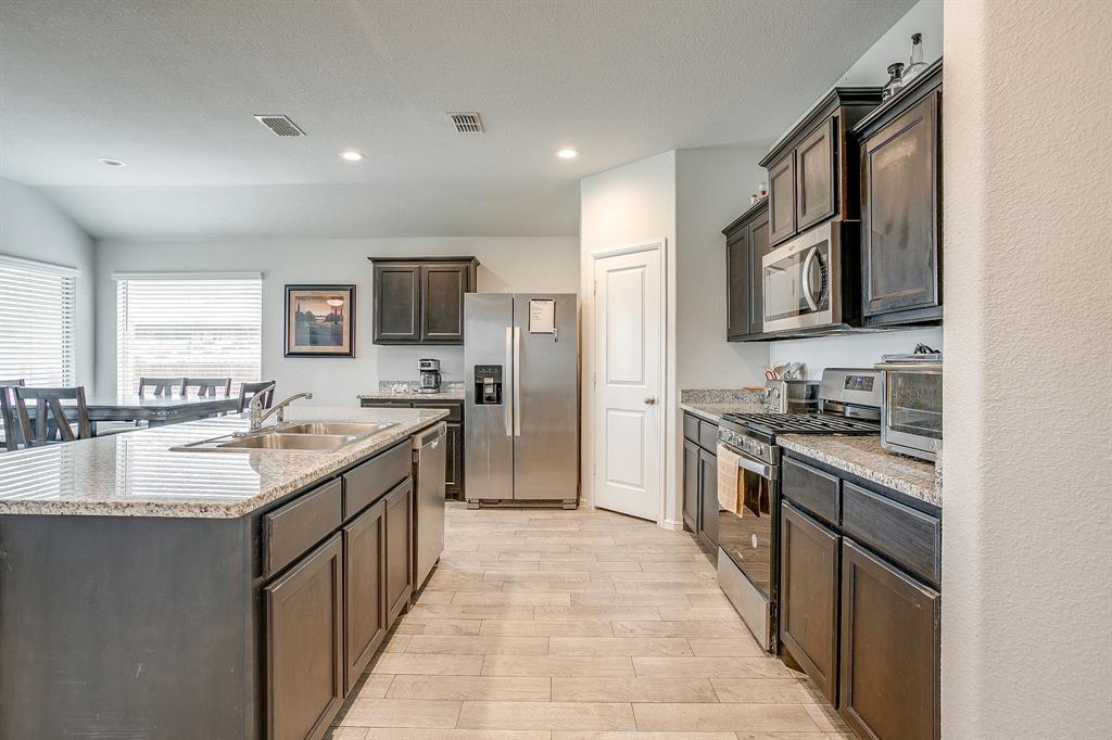 2313 Stallings Road Fort Worth, TX 76108 - Photo 10 of 30 a large kitchen with stainless steel appliances granite countertop a sink stove top oven and refrigerator