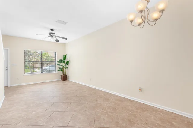 an empty room with windows and ceiling fan