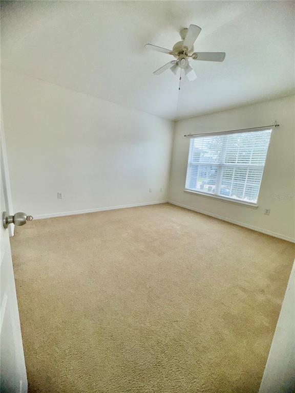 6404 South Goldenrod Road, Unit 2A Orlando, FL 32822 - Photo 31 of 40 an empty room with a chandelier fan and windows