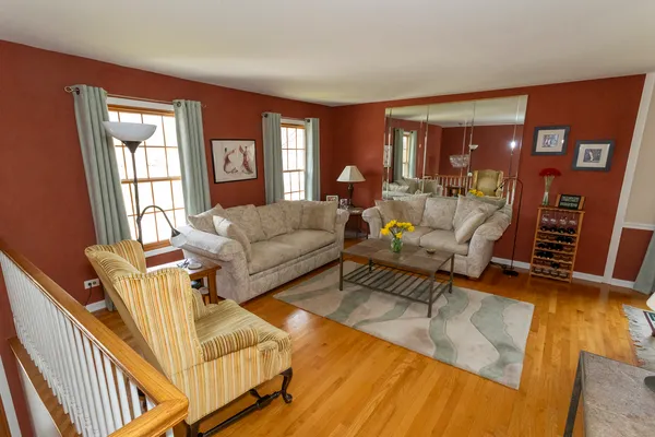 a living room with furniture a large window and wooden floor