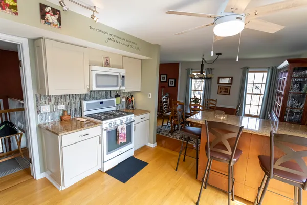 a kitchen that has a lot of cabinets in it and wooden floor