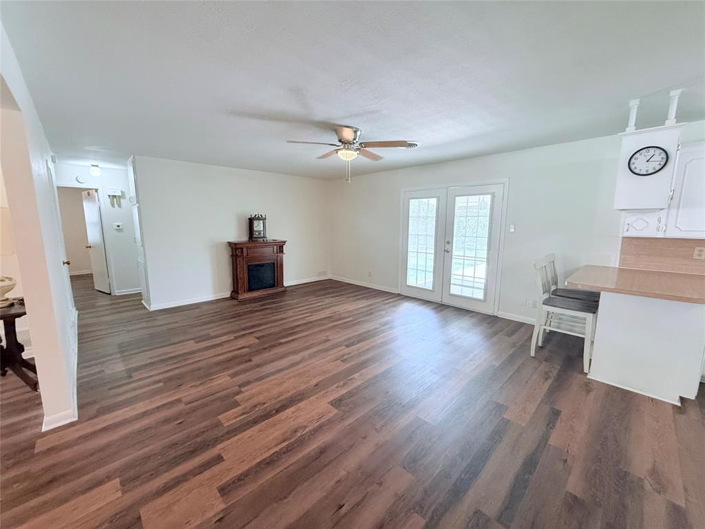 160 Bob White Road Denison, TX 75020 - Photo 5 of 29 Expansive room featuring wood-finish flooring, a built-in fireplace mantel, and ceiling fan