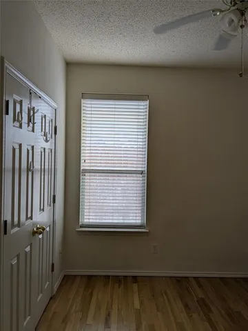 a view of a room with wooden floor and a window