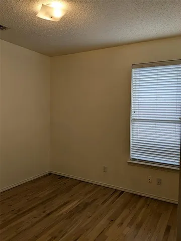 a view of a room with wooden floor and a window