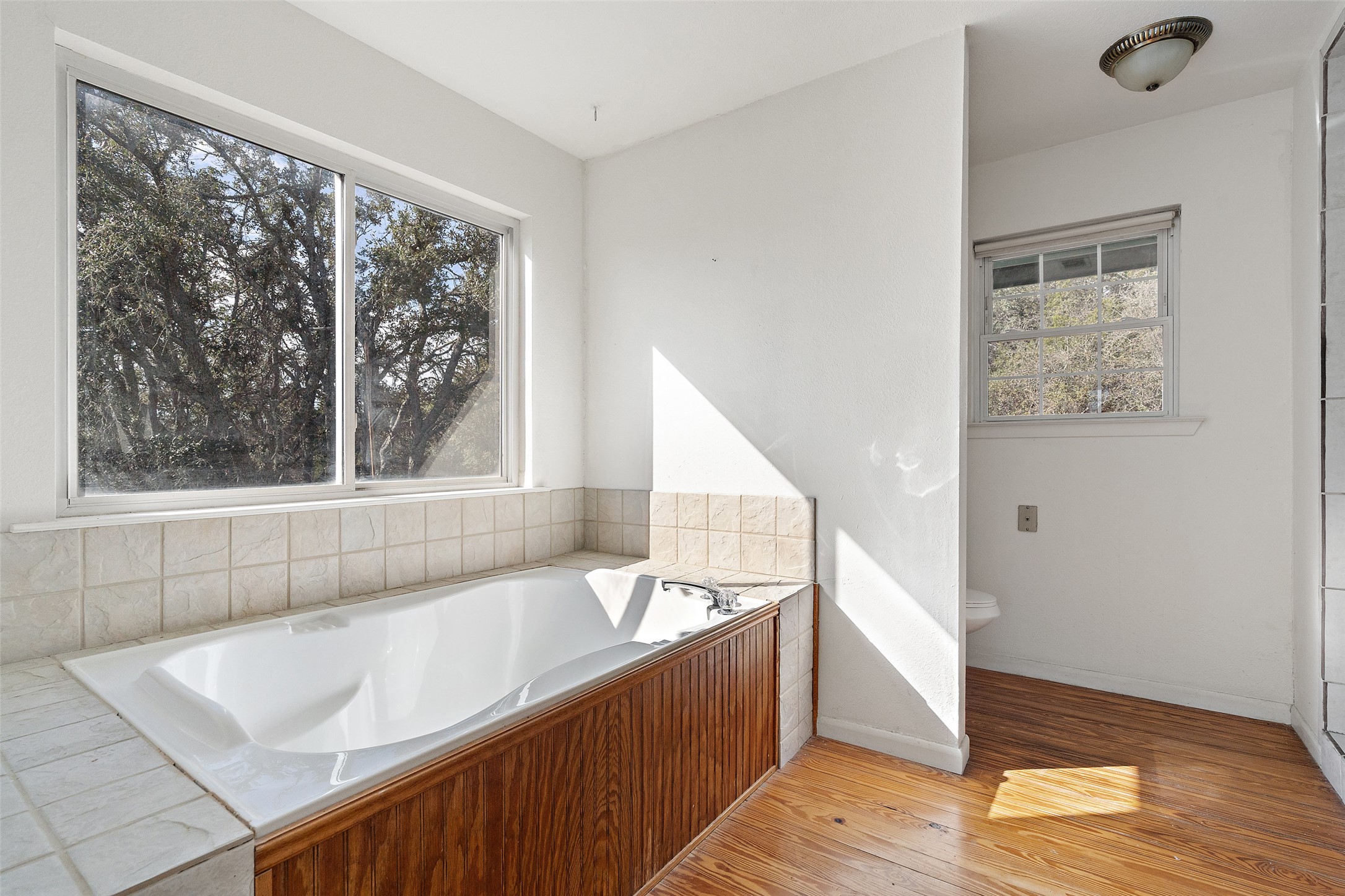 1401 Pursley Road Dripping Springs, TX 78620 - Photo 12 of 35 Primary bathroom featuring a garden tub and light wood-style floors