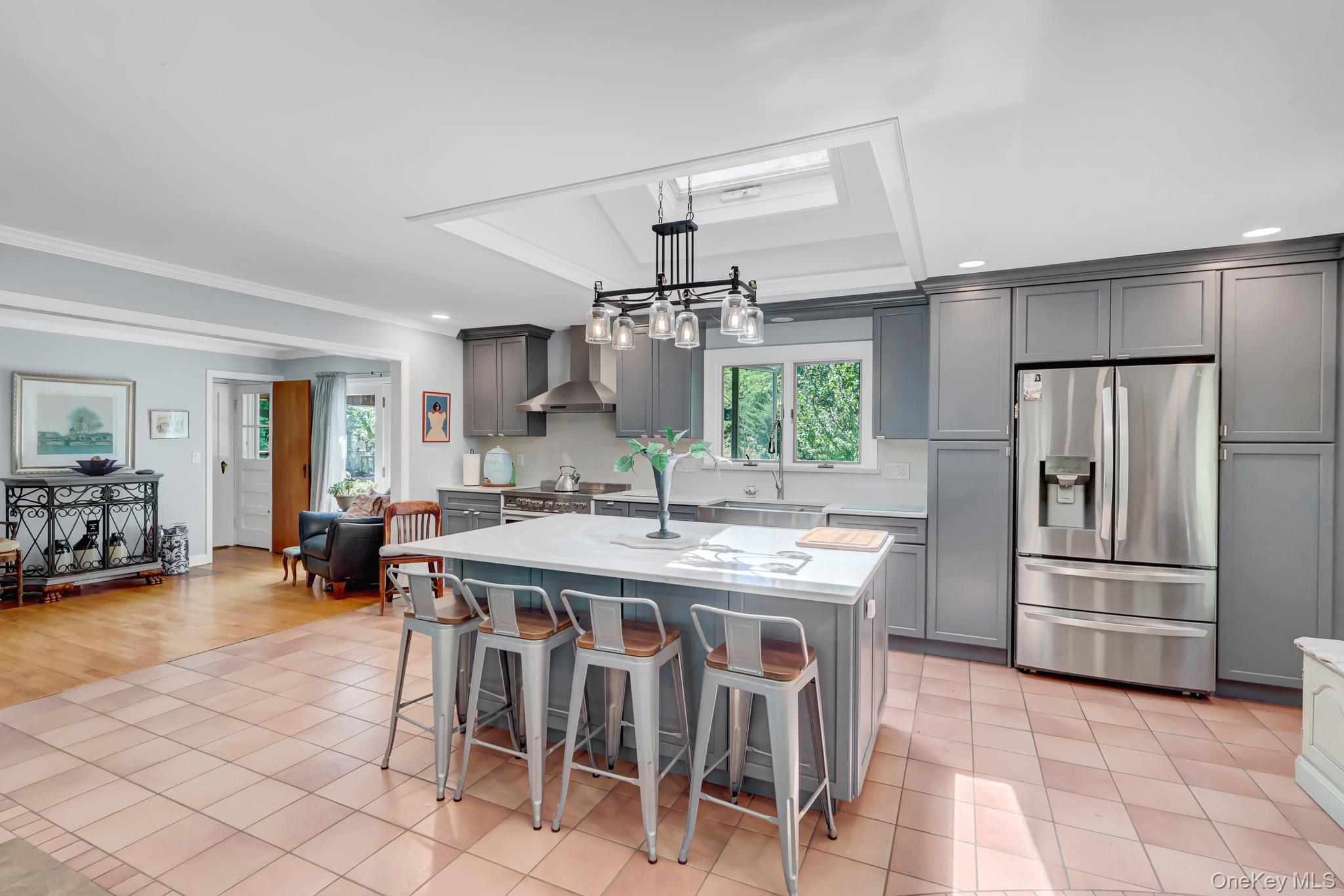 100 Elwood Road Northport, NY 11768 - Photo 7 of 39 Spacious kitchen featuring an expansive center island with seating, stainless steel appliances, grey cabinetry, a drop ceiling with recessed lighting, and a skylight