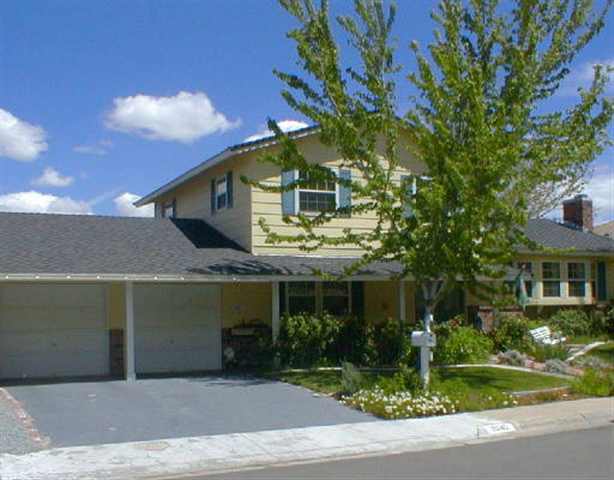 a front view of a house with a yard garage and outdoor seating