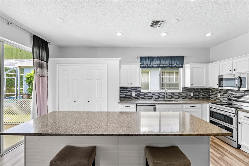 10443 Peppergrass Court Trinity, FL 34655 - Photo 13 of 62 a kitchen with stainless steel appliances granite countertop a stove a sink and a refrigerator