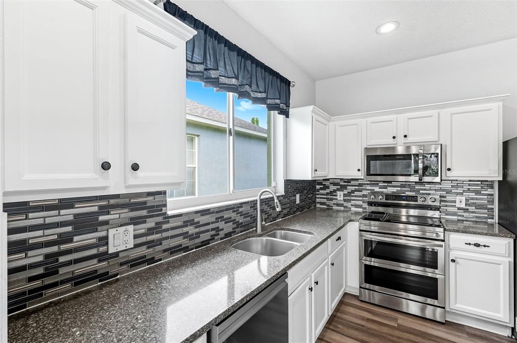 10443 Peppergrass Court Trinity, FL 34655 - Photo 16 of 62 a kitchen with stainless steel appliances a stove sink and cabinets